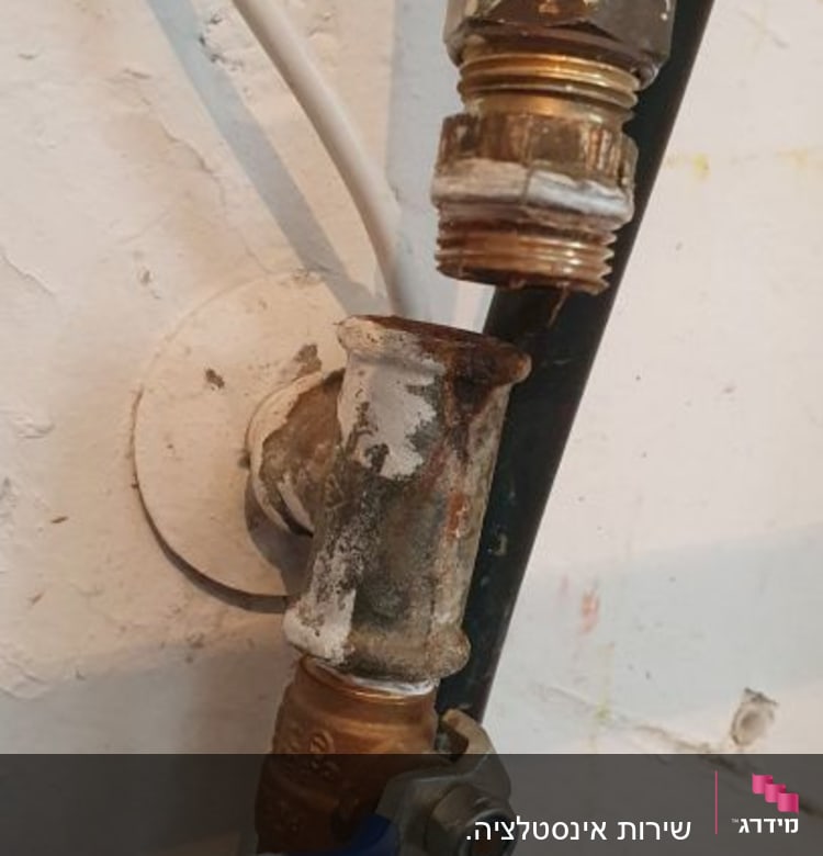 צינור מים עם ברז כחול וחיבורים חלודים